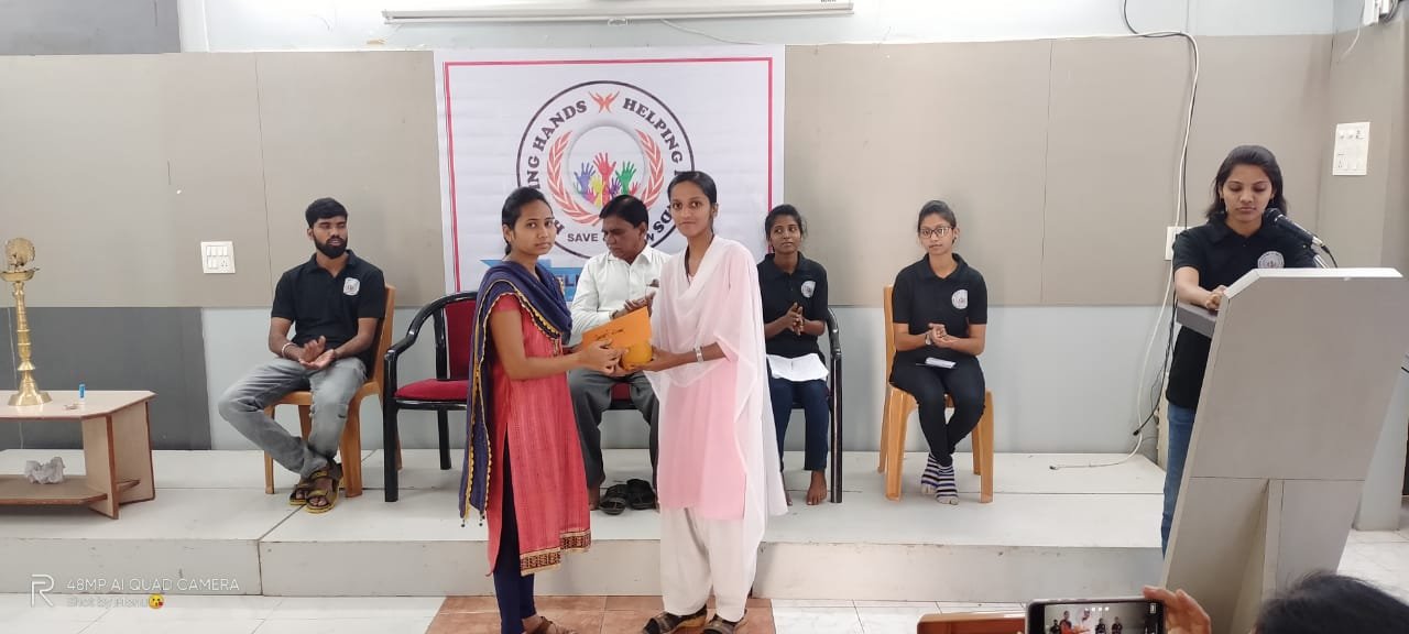 A student receiving a gift from Helping Hand Save And Learn volunteers on stage