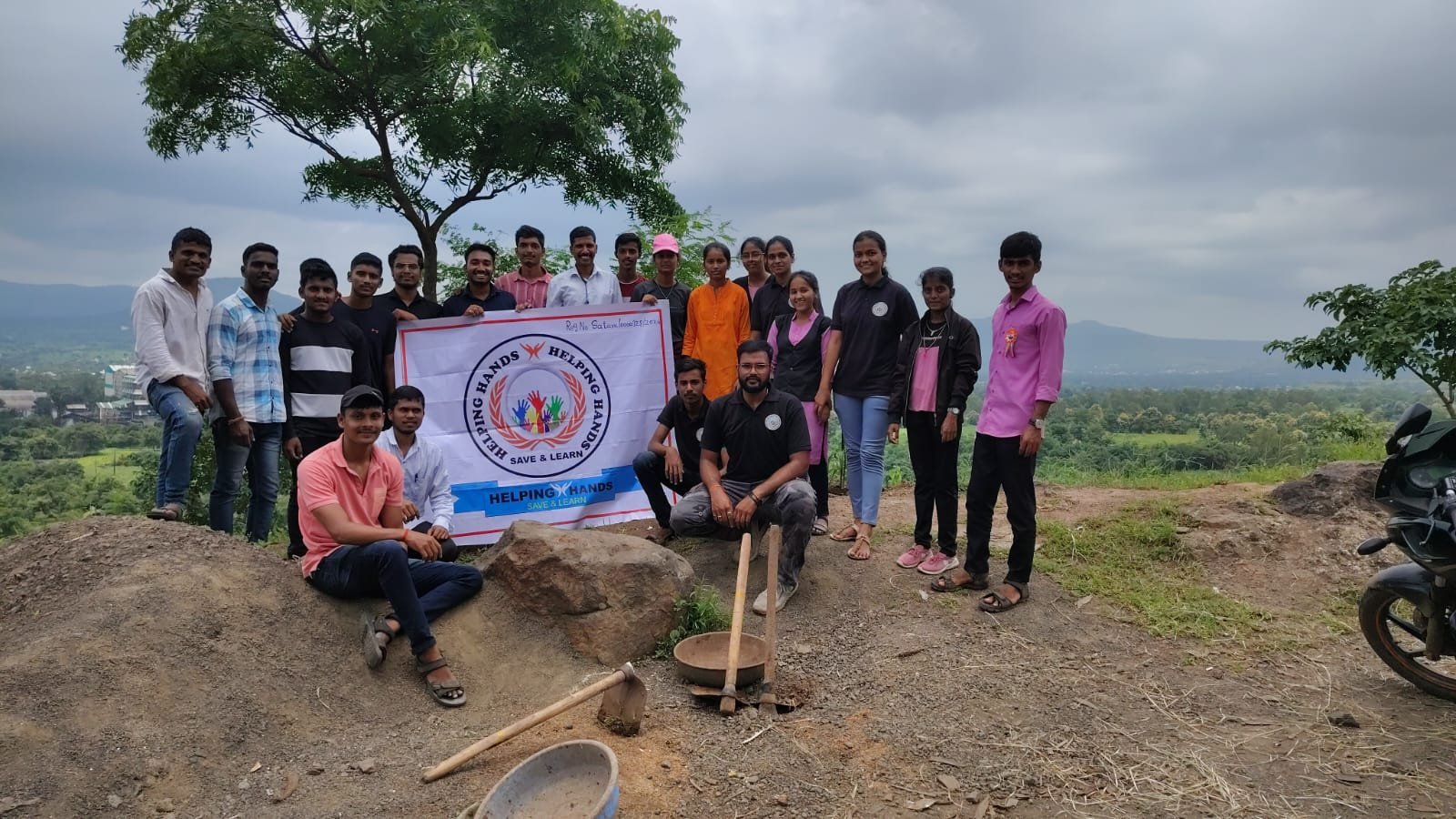 Helping Hand Save And Learn volunteers with their banner during a hilltop activity